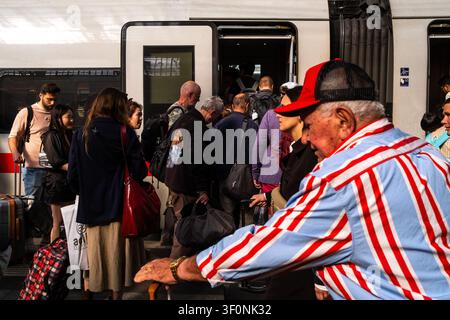 Crowded platform view of travellers boarding through open Deutsche Bahn DB train doors at Koln Hauptbahnhof in Cologne, North Rhine-Westphalia, German Stock Photo