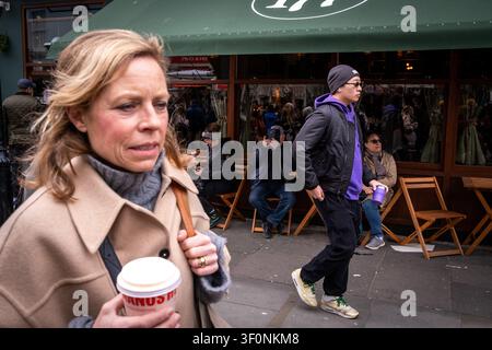 People walk and sit outside the 177 green awning cafe and shopfront at Portobello Road Market in Notting Hill, London, England, United Kingdom, March Stock Photo
