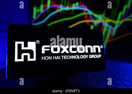 Hon Hai Precision Industry Co Ltd Foxconn Logo Displayed On A Smartphone Screen In Front Of A Computer Showing Stock Market Financial Performance Char Stock Photo
