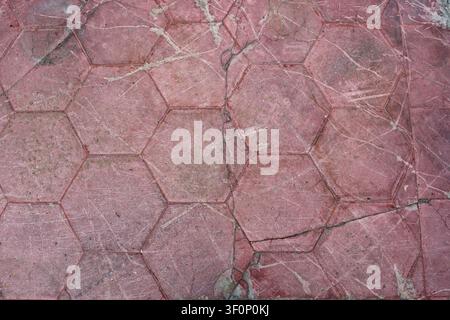 Aged red hexagonal tile floor texture with scratches and cracks Stock Photo