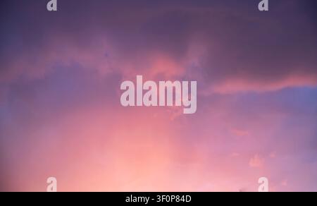 Dramatic Storm Clouds With Blue Opening and Glowing Sunset Light Stock Photo