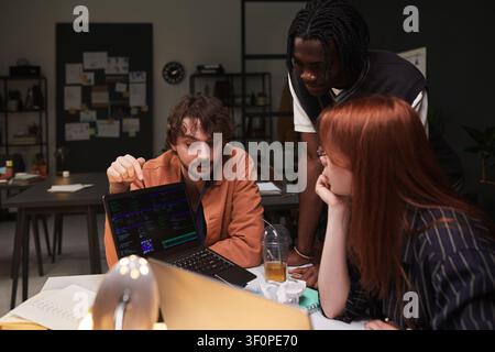 Diverse Adult Team Reviewing Coding Project in Startup Office Stock Photo