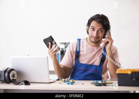 Young male contractor repairing computer Stock Photo