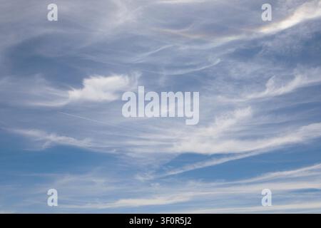 A sunny blue sky with light white cloud cover in the summer Stock Photo
