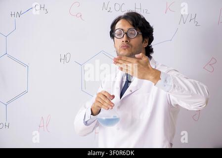 Young funny chemist in front of white board Stock Photo