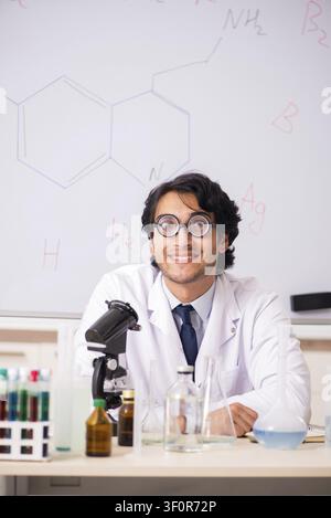 Young funny chemist in front of white board Stock Photo