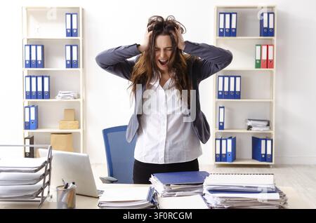 Young female employee unhappy with excessive work Stock Photo