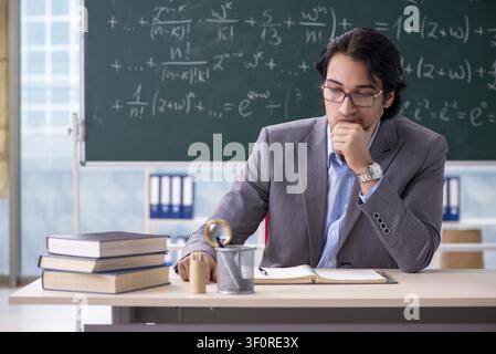 Young handsome math teacher in classroom Stock Photo