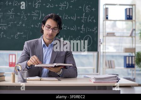 Young handsome math teacher in classroom Stock Photo