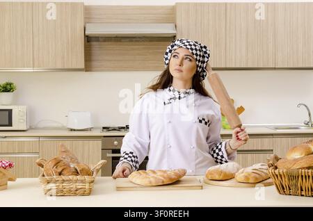 Young female baker working in kitchen Stock Photo