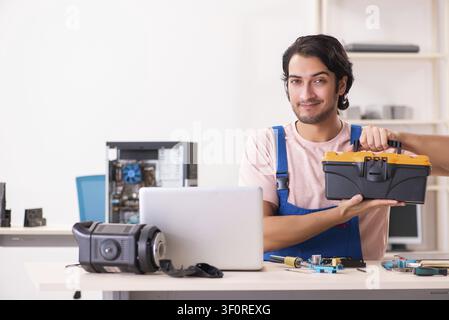 Young male contractor repairing computer Stock Photo