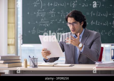 Young handsome math teacher in classroom Stock Photo