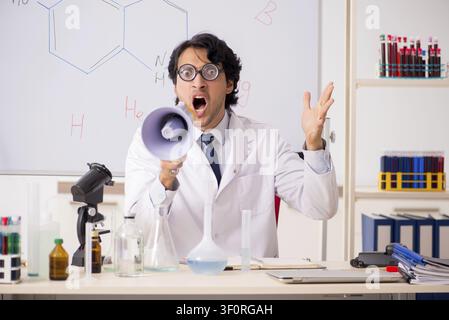 Young funny chemist in front of white board Stock Photo