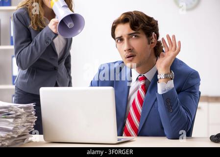 Deaf employee using hearing aid talking to boss Stock Photo