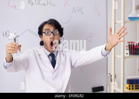 Young funny chemist in front of white board Stock Photo