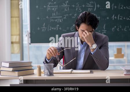 Young handsome math teacher in classroom Stock Photo