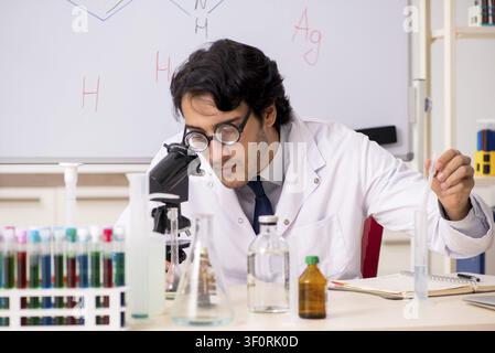 Young funny chemist in front of white board Stock Photo
