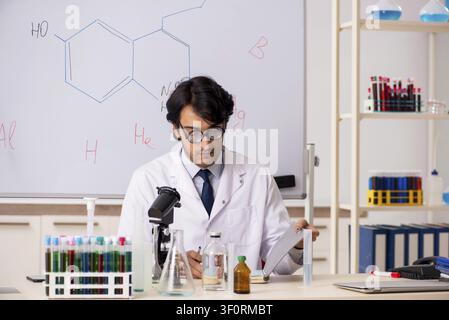 Young funny chemist in front of white board Stock Photo