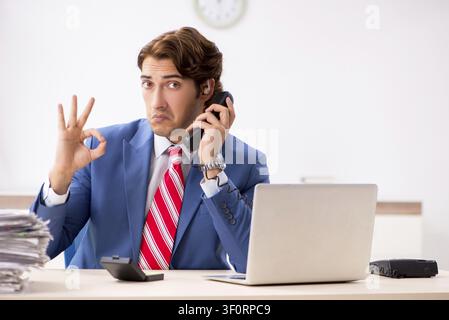 Deaf employee using hearing aid in office Stock Photo