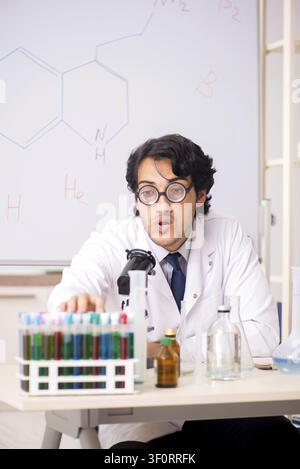 Young funny chemist in front of white board Stock Photo