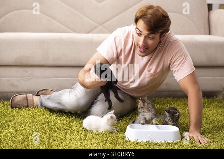 Young man playing with kitten at home Stock Photo