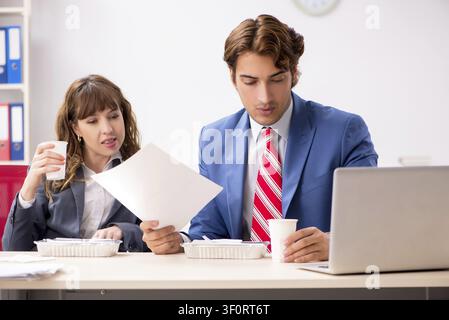 Two colleagues having lunch break at workplace Stock Photo