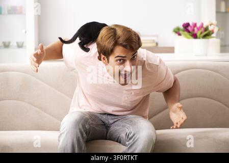 Young man playing with kitten at home Stock Photo
