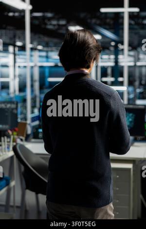 System administrator uses a computer in a data center to deploy software updates, configure hardware, and support reliable operations. Stock Photo