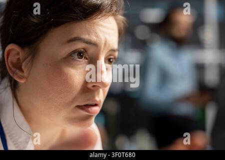Concerned computer scientist reviews warning messages in a data center while troubleshooting errors affecting equipment performance. Stock Photo