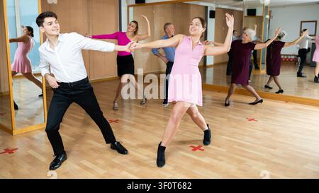 Young pair practicing ballroom dance in dance studio Stock Photo