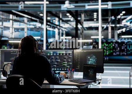 Data center IT professional reviews data analysis graph to reduce infrastructure failure. Stock Photo