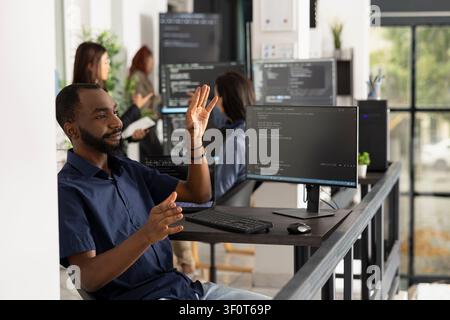 Male programmer interacts with invisible holographic interface in office. Developer explores augmented reality and advanced human computer interaction while working on innovative technology solutions. Stock Photo