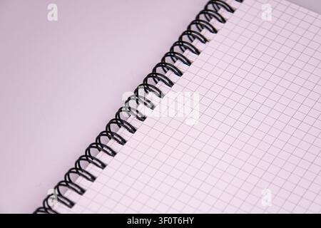 Minimalist spiral notebook close-up, grid pages, textured paper, clean studio background, soft even lighting, black binding, white pages, faint lines, Stock Photo