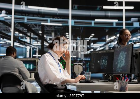 Exhausted IT expert handles fatigue in a data center after a long hardware troubleshooting session at a computer workstation. Stock Photo