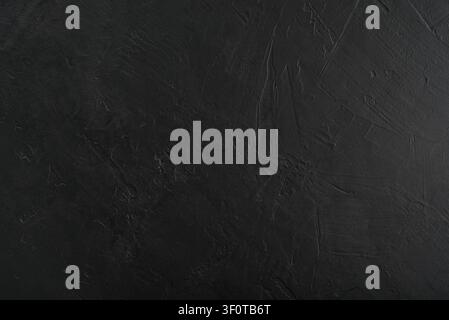 Black textured concrete wall background with trowel strokes. Dark industrial loft surface with rough cement texture, ideal for product presentation, b Stock Photo