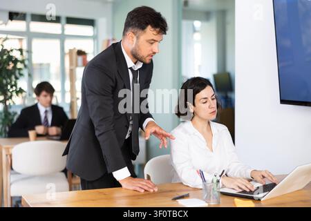 Office employees are working on a project and checking data on a laptop Stock Photo