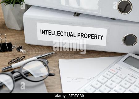 Intellectual Property on folder and stationery on wooden table, closeup Stock Photo