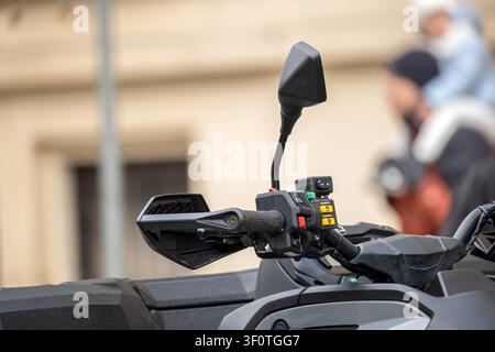 Quad bike handlebar controls and mirror closeup, modern ATV cockpit detail with hand guard, switches and throttle grip, off road vehicle at outdoor ur Stock Photo