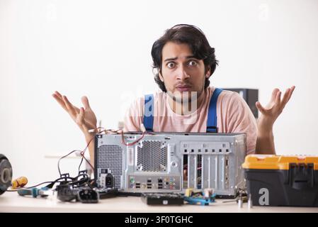 Young male contractor repairing computer Stock Photo