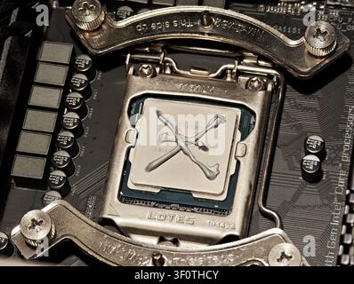Intel Core CPU seated in LGA motherboard socket with X pattern thermal paste, closeup top view of processor repasting for IT PC repair, cooling mainte Stock Photo