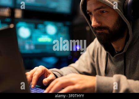 Closeup of programmer looking at screen with focus, preventing hacking, cybercrime and surveillance issues in office. White man writes code on laptop, developing secure connections for startup company Stock Photo