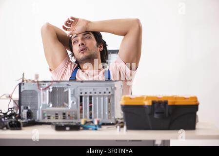 Young male contractor repairing computer Stock Photo