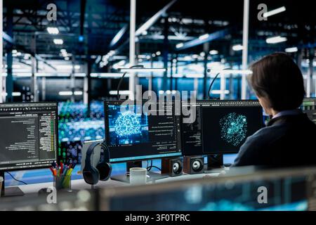 Server room admin running simulations for AI driven prediction, tracking performance. Stock Photo