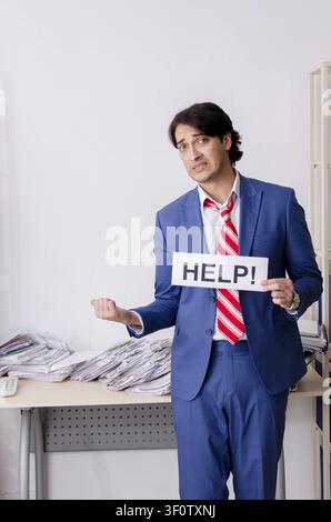 Young businessman employee unhappy with excessive work Stock Photo