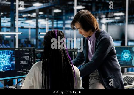 Data center manager reviews artificial intelligence systems and machine learning processes inside a data center. Stock Photo