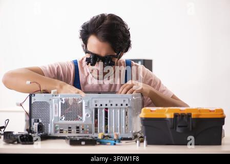 Young male contractor repairing computer Stock Photo