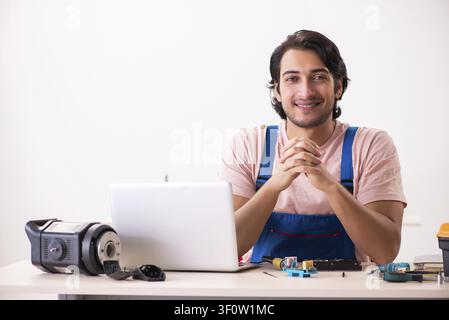 Young male contractor repairing computer Stock Photo