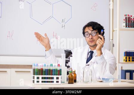 Young funny chemist in front of white board Stock Photo