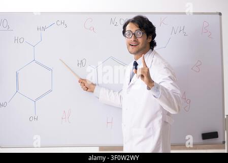 Young funny chemist in front of white board Stock Photo