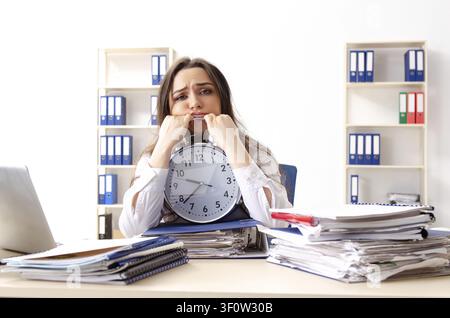 Young female employee unhappy with excessive work Stock Photo